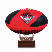 A red and black Essendon Sherring football displayed on a clear acrylic stand with a dark wood base, set against a plain white background.