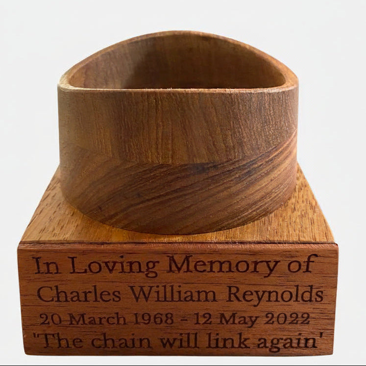 Wooden stand for football urn with engraved text on a white background