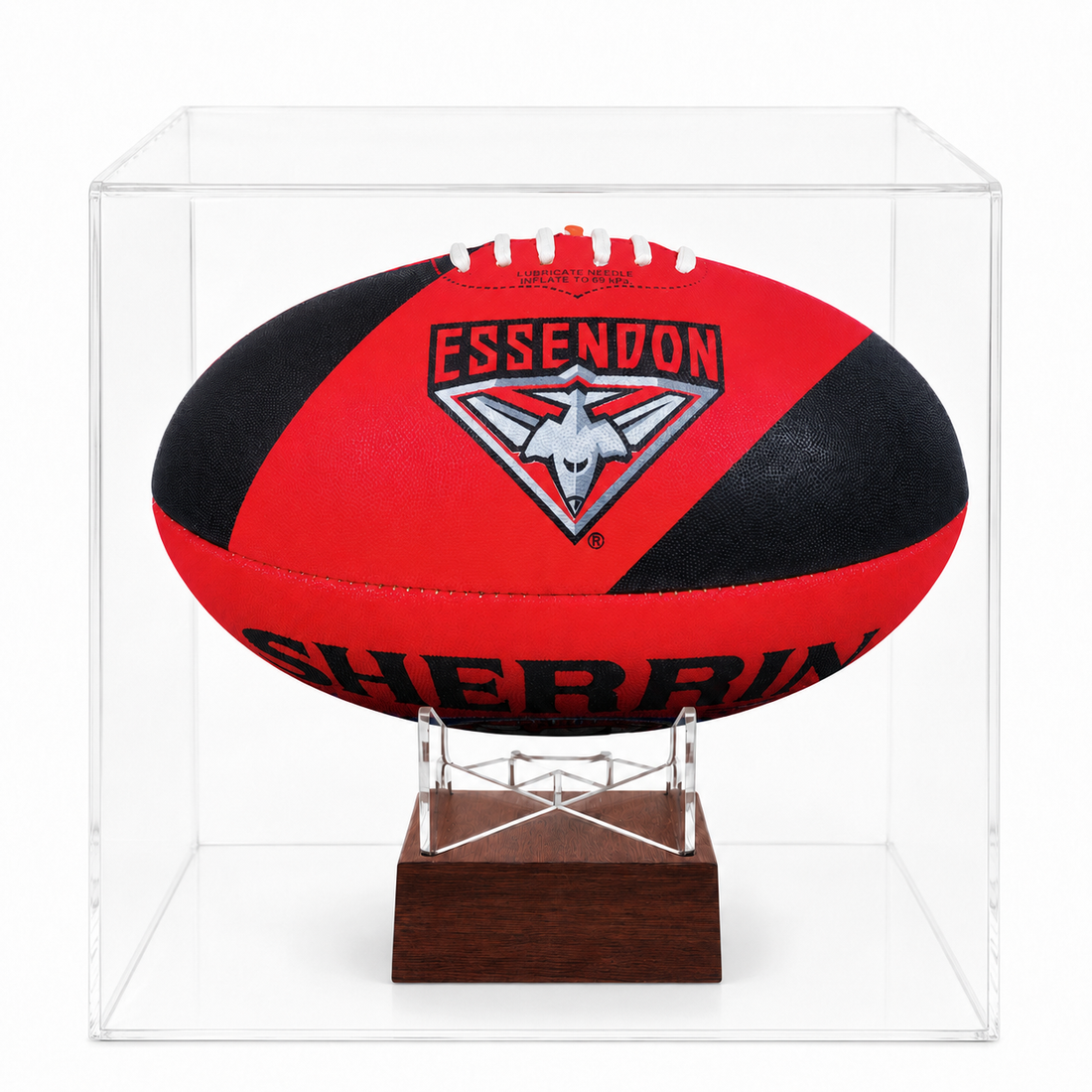 A red and black Essendon Football Club rugby ball mounted on a clear acrylic display case over a dark wood base, shown against a white background.