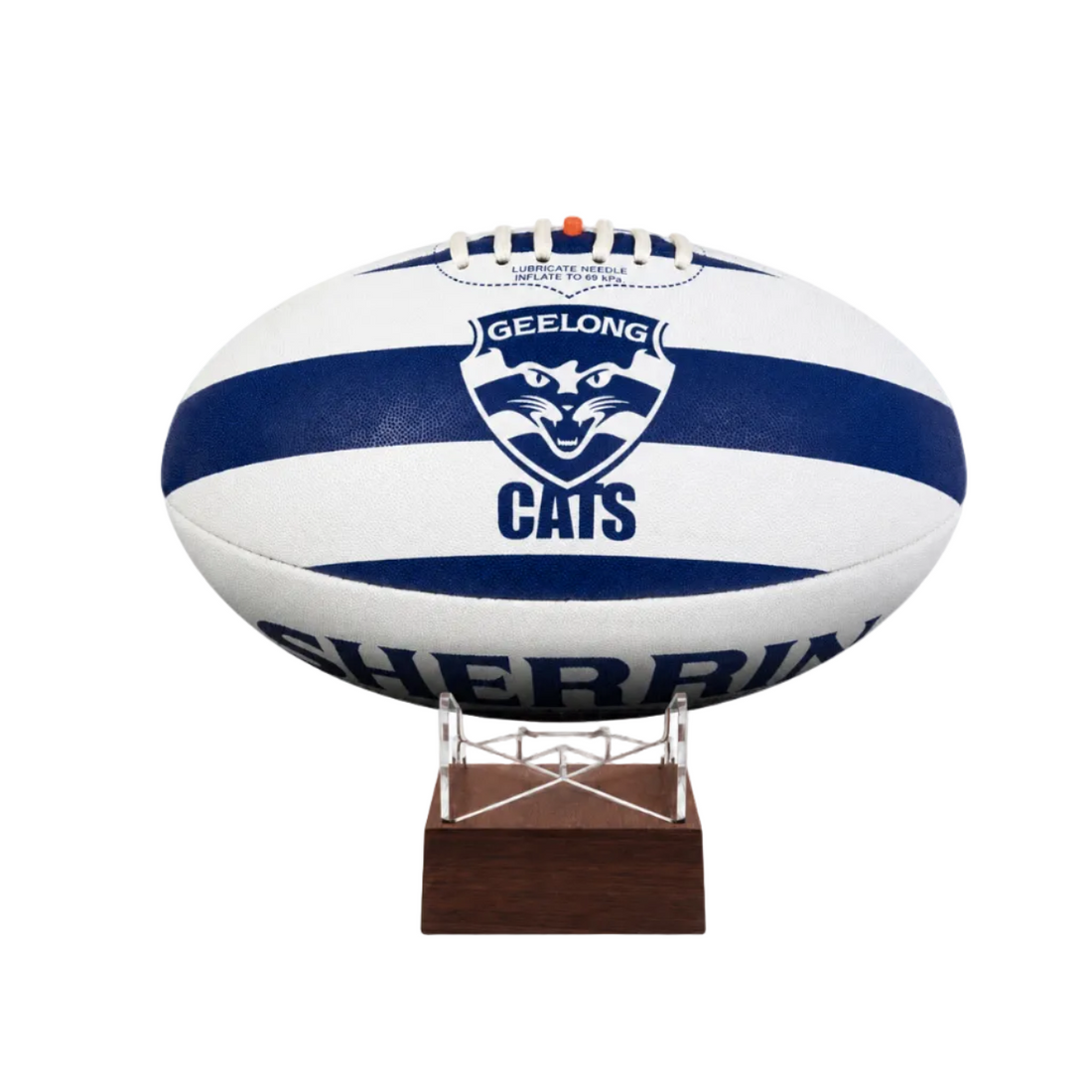 A white and navy blue Geelong Cats  AFL ball displayed on a small wooden stand against a plain white background.