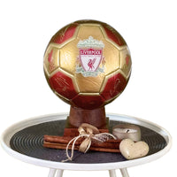 Gold and red soccer ball with Liverpool FC logo on a decorative stand.