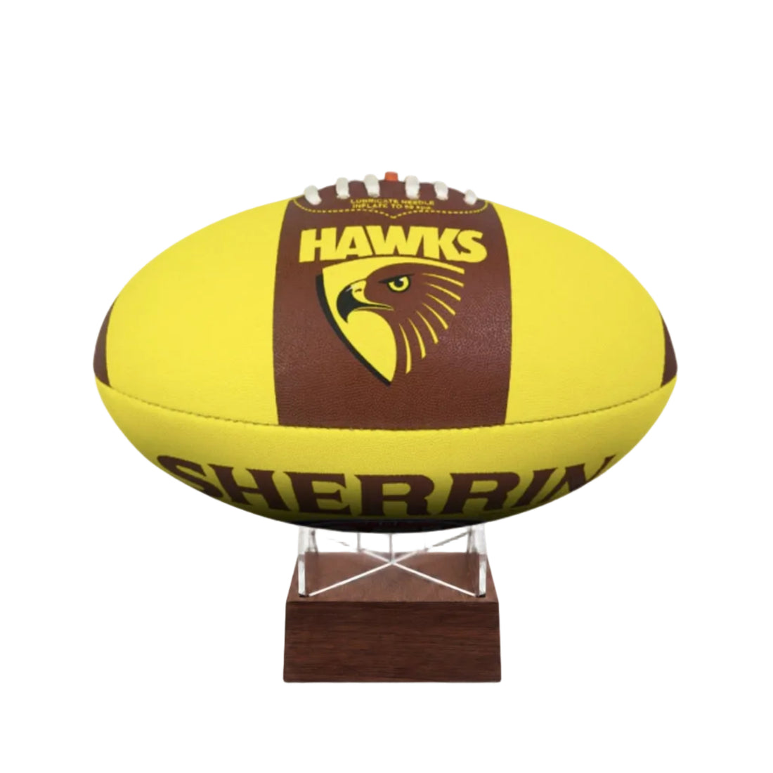 A yellow and brown Sherrin Hawks football displayed on a small wooden stand against a white background.