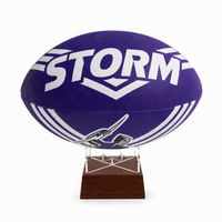 A purple Storm rugby ball with white lettering and graphics, displayed on a clear acrylic stand with a dark brown wooden base against a white background.