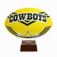 A yellow Cowboys rugby ball mounted on a clear acrylic stand with a dark brown wooden base, set against a plain white background.