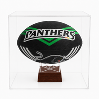 A black Penrith Panthers rugby ball displayed inside a clear acrylic cube case on a dark wood stand, photographed against a clean white background.