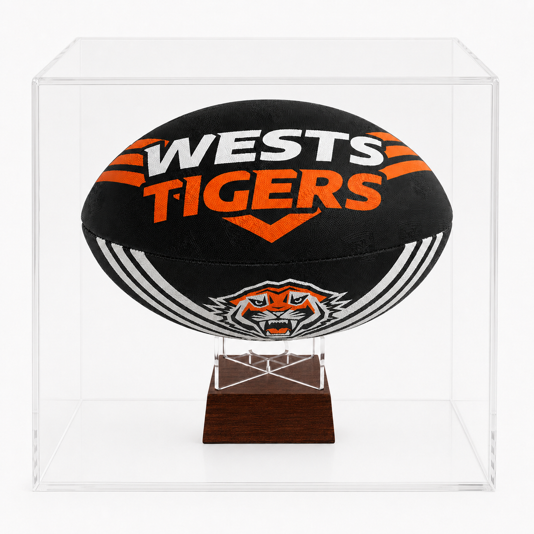 A black Wests Tigers rugby ball urn displayed inside a clear acrylic display case on a dark wood stand.